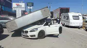 Edremit'te rüzgarın yıktığı dev reklam panosu otomobilin üzerine düştü
