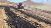 Tarlada çıkan yangını iş makineleri durdurdu