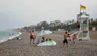 Antalya sıcağında yağmura yakalananlar sahili terk etmedi