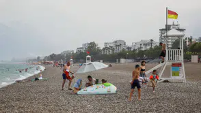Antalya sıcağında yağmura yakalananlar sahili terk etmedi