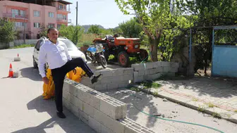 Evinin kapısına duvar örülen adam briketlerin üzerinden atlıyor