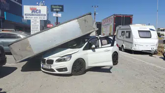 Edremit'te rüzgarın yıktığı dev reklam panosu otomobilin üzerine düştü