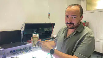 Tamirci dükkanında şişmiş telefon bataryası aniden alev aldı