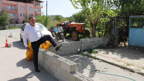 Evinin kapısına duvar örülen adam briketlerin üzerinden atlıyor