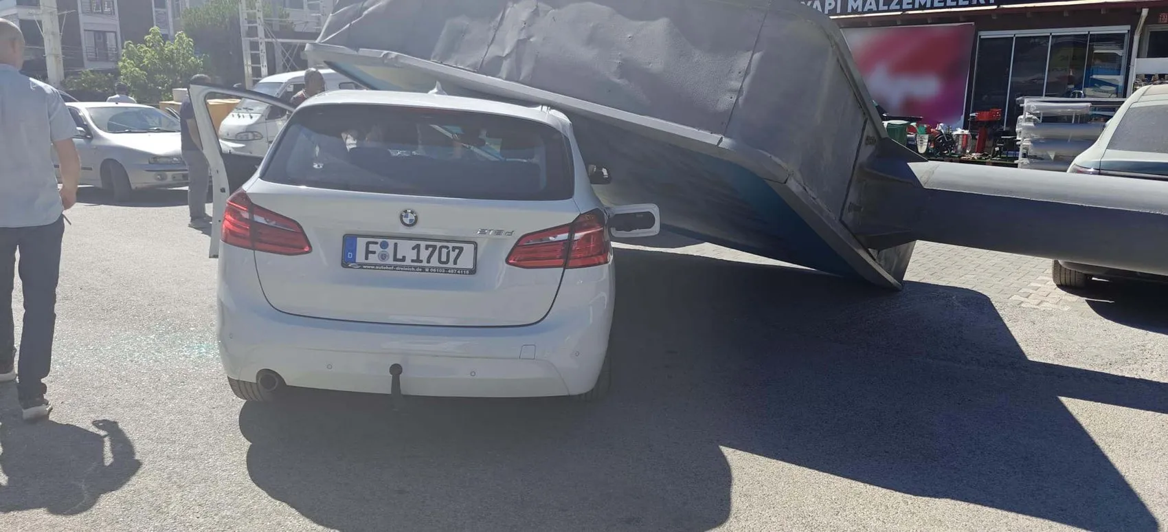 Edremit'te rüzgarın yıktığı dev reklam panosu otomobilin üzerine düştü