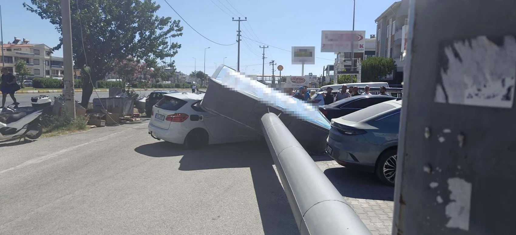 Edremit'te rüzgarın yıktığı dev reklam panosu otomobilin üzerine düştü