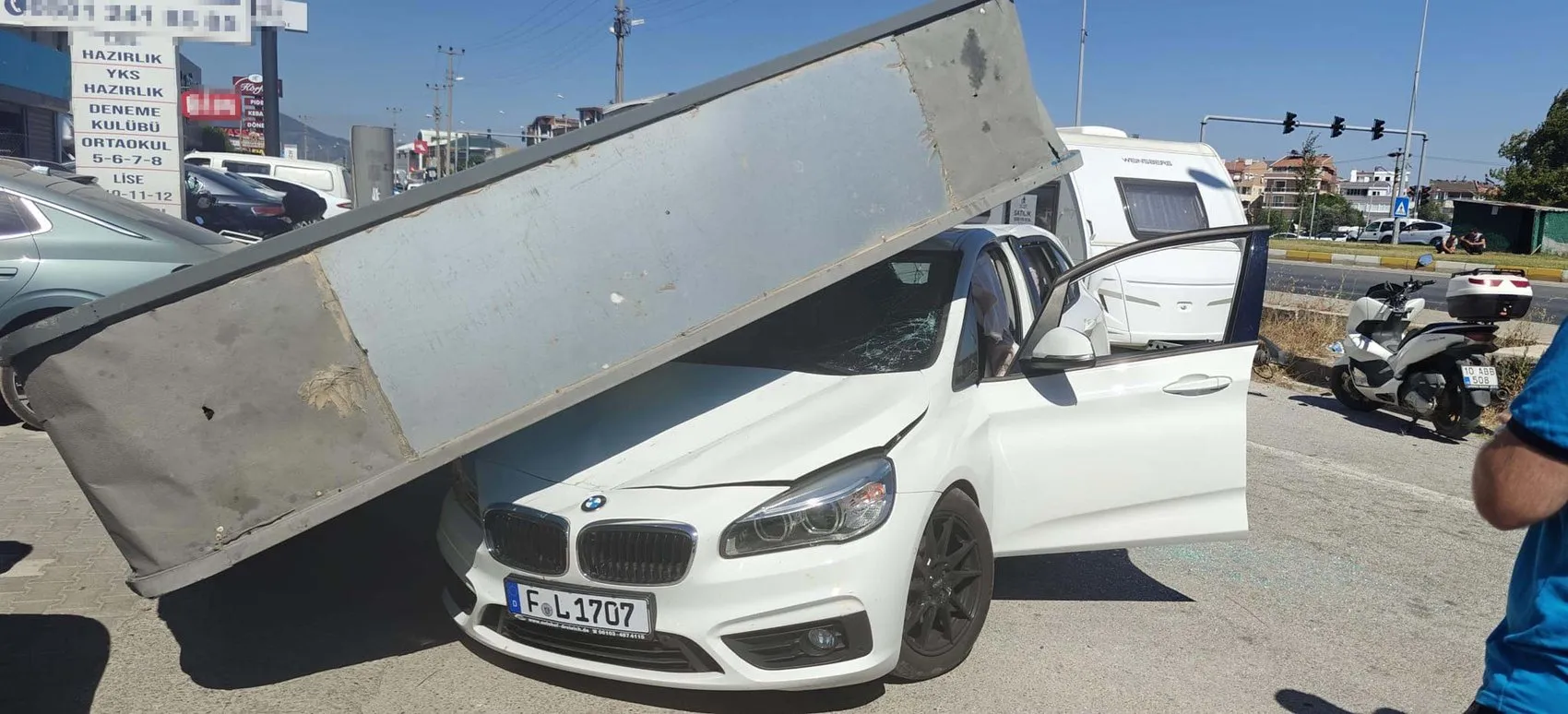 Edremit'te rüzgarın yıktığı dev reklam panosu otomobilin üzerine düştü
