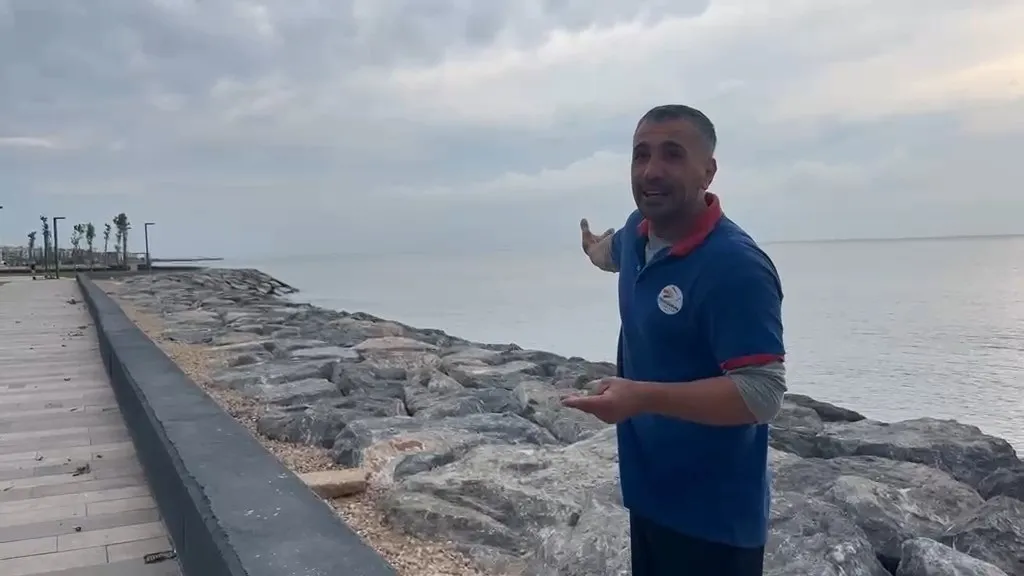 Hatay'da yürek ısıtan an Temizlik görevlisi yaralı leyleği kıyafetleriyle denize girip kurtardı