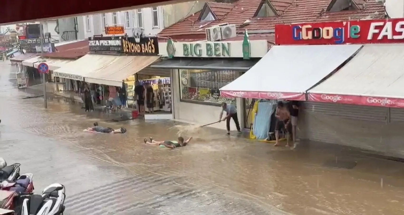 Fethiye'de sağanak yağış eğlenceye dönüştü: Sokakları deniz sanıp şişme yatakla yüzdüler