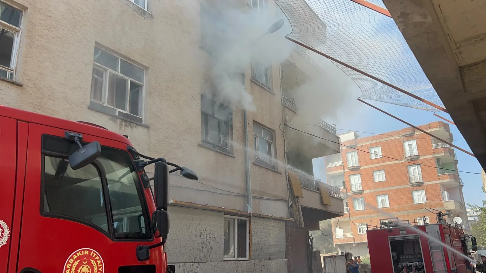 Bismil'de alevlerin arasında kalan kadına konteynerli kurtarma operasyonu