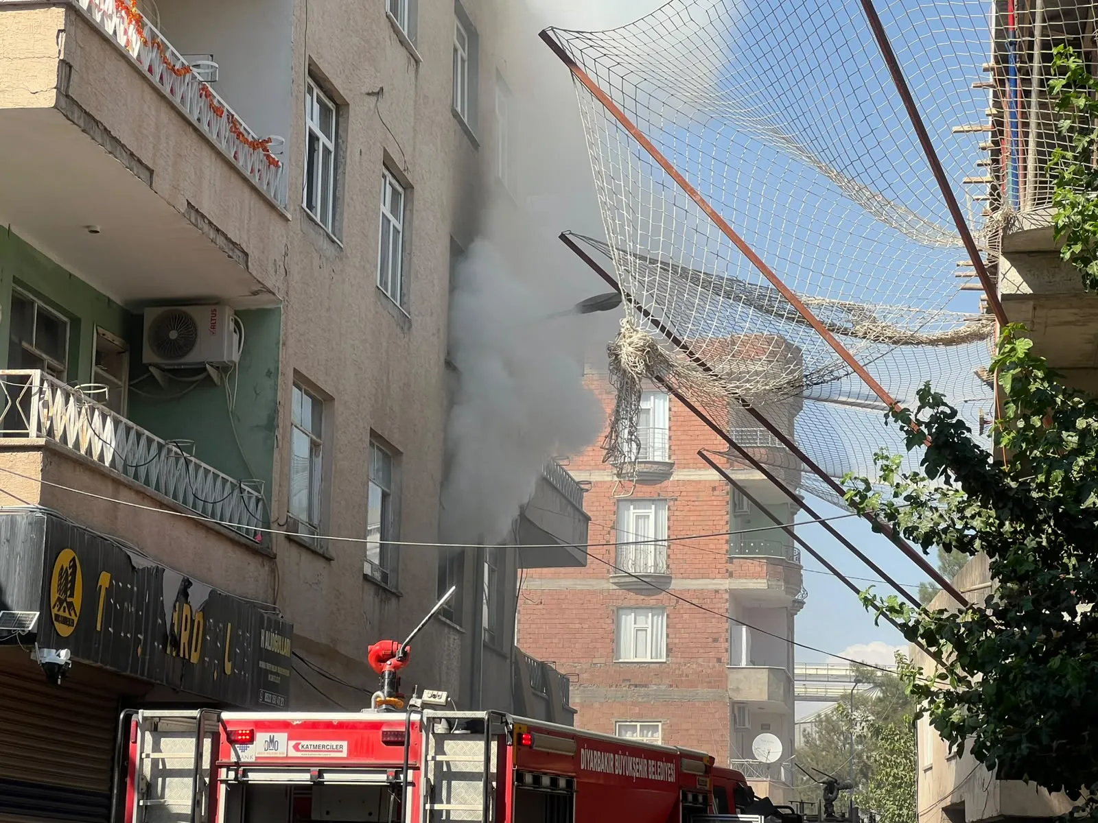 Bismil'de alevlerin arasında kalan kadına konteynerli kurtarma operasyonu