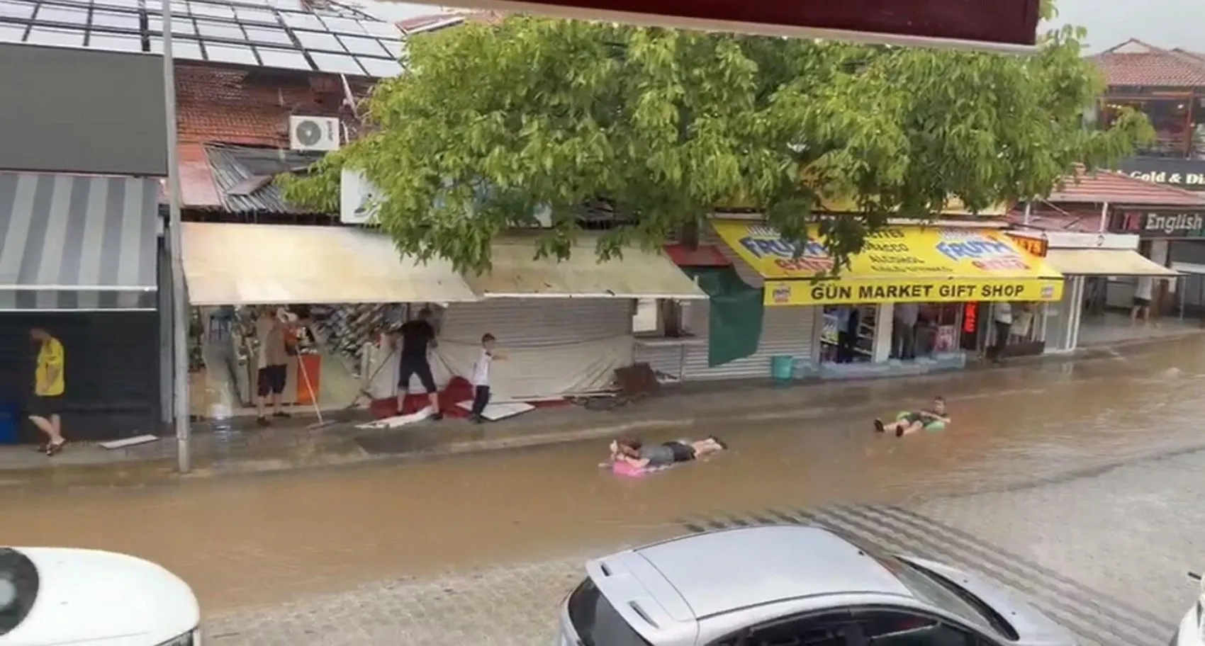 Fethiye'de sağanak yağış eğlenceye dönüştü: Sokakları deniz sanıp şişme yatakla yüzdüler